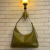 Olive Green hobo shoulder bag with a tonal strap against a brick wall