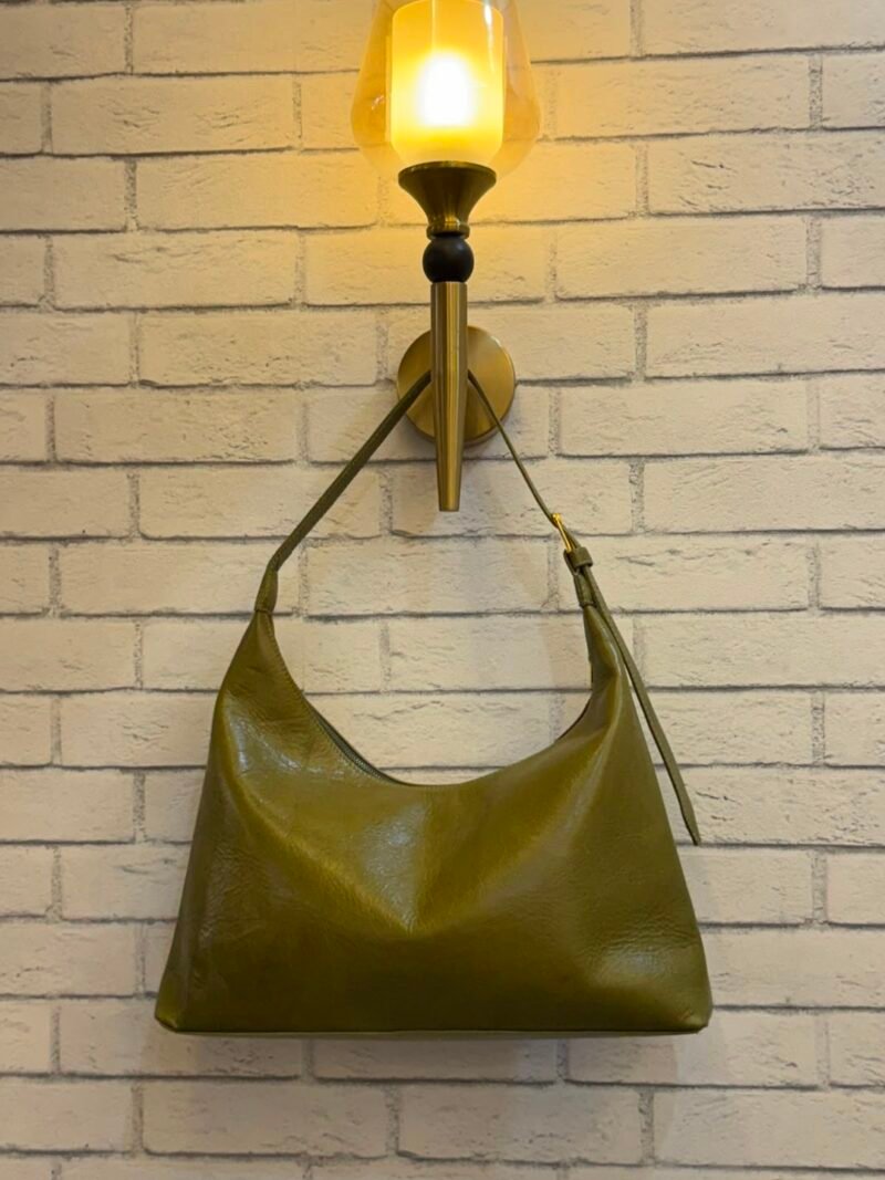 Olive Green hobo shoulder bag with a tonal strap against a brick wall